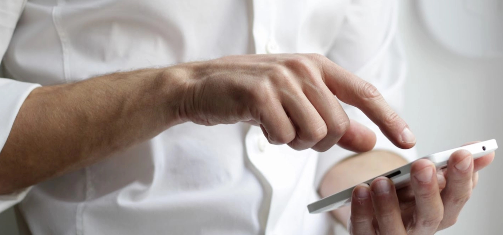 Hand tapping on a smartphone screen, interacting with a mobile app.